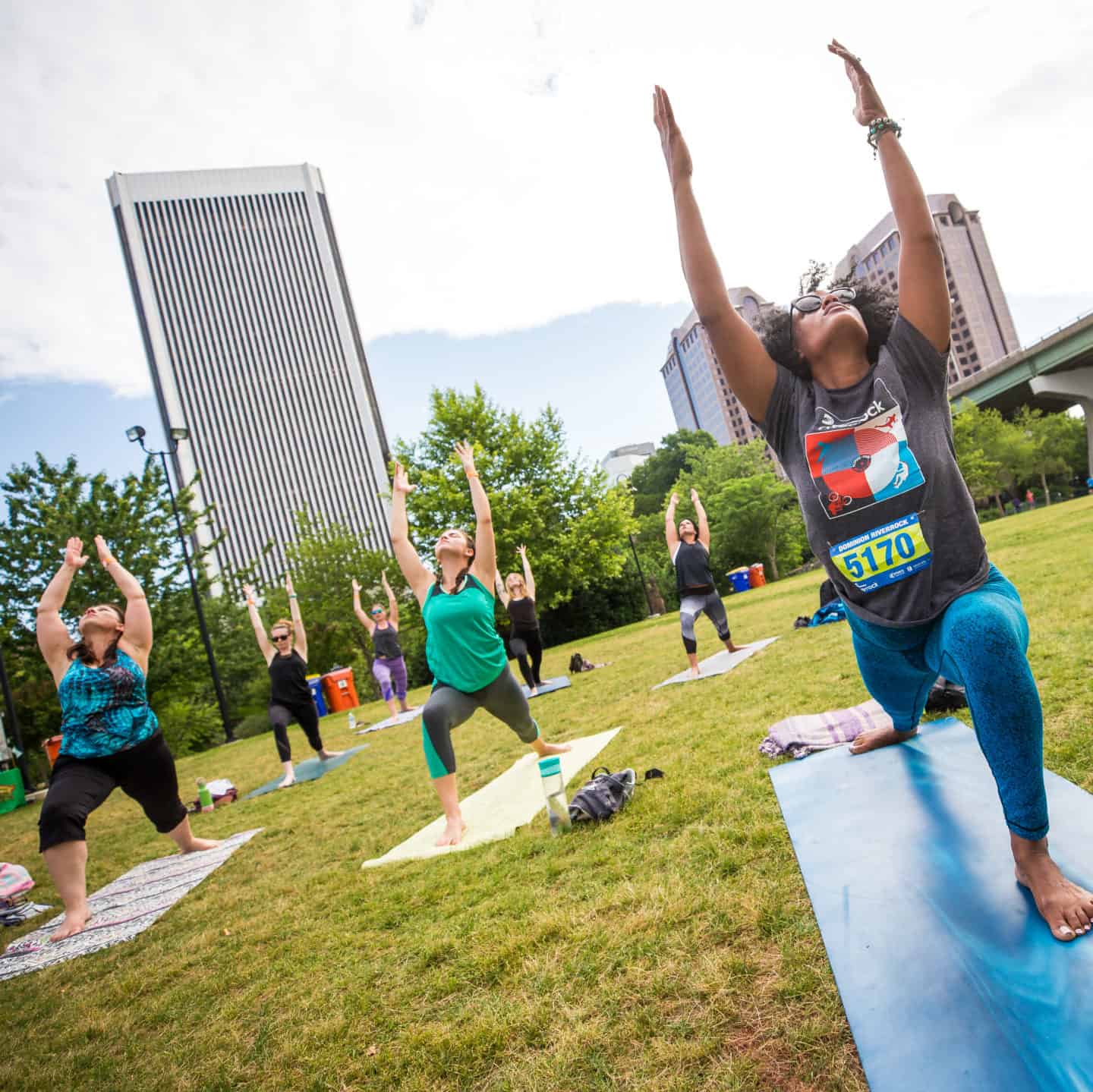outdoor yoga. Woman in foreground in warrior 1 pose.